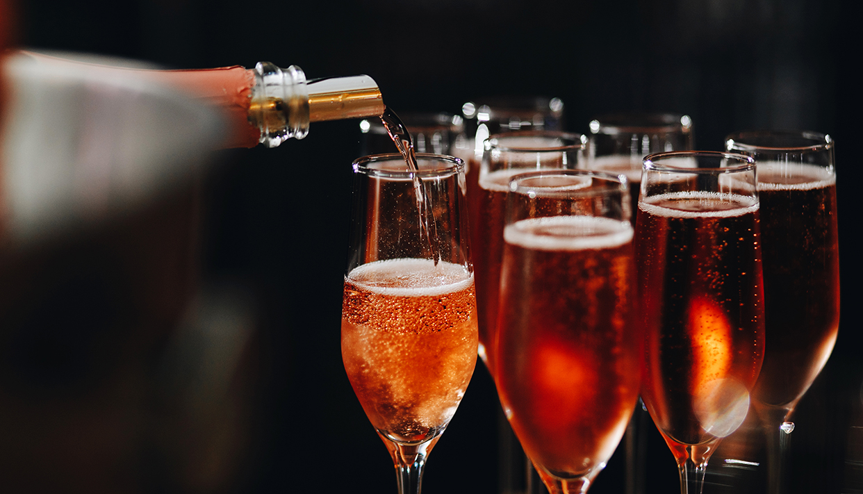 Rose champagne – sparkling wine in glasses; catering at reception for wedding or similar event